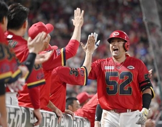 　６回、本塁打を放ちナインとタッチを交わす広島・末包＝マツダ