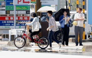 　「逃げ水」が見られた静岡市駿河区を歩く人たち。気温４１・４度を観測した＝６日午後