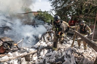 　ロシア軍による爆撃を受けた住宅の消火に当たるウクライナの消防士ら＝９日、ウクライナ東部ドネツク州コンスタンチノフカ（ゲッティ＝共同）