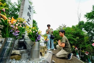　日航機墜落事故現場の尾根に立つ「昇魂之碑」で手を合わせる遺族＝１２日午前、群馬県上野村