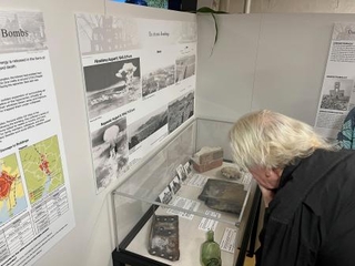 　１２日、米ハワイ・真珠湾の戦艦ミズーリ記念館で始まった「原爆・平和展」で、展示資料を見る来場者（共同）