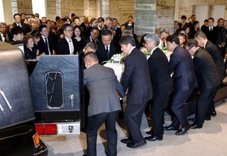 　永島昭浩さん（手前左から２人目）らに運ばれる釜本邦茂さんのひつぎ＝１３日午後、大阪府吹田市