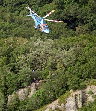 　北海道・知床の羅臼岳で登山者を救助する道警のヘリコプター＝１４日午後２時３３分（共同通信社ヘリから）