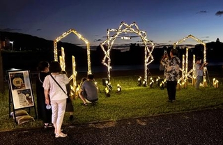 　原鶴温泉に設置された竹製のオブジェを訪れた参加者ら＝７月、福岡県朝倉市（同県提供）