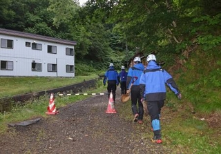 　１５日午前、閉鎖された羅臼岳の登山口から入山する捜索隊＝北海道斜里町