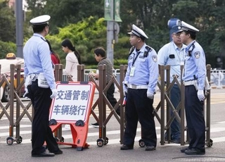 　北京市内で車両の通行を規制する警察官＝１６日（共同）