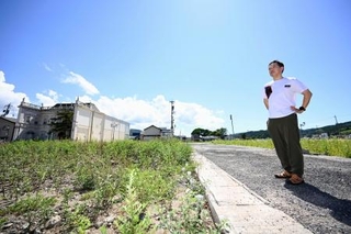 　実家の跡地（左）を訪れた清水宏紀さん＝９日、石川県輪島市