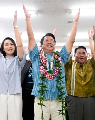 　沖縄県石垣市長選で５選を決め、万歳する中山義隆氏（中央）＝１７日夜、石垣市