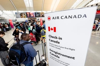 　１９日、カナダ航空最大手エア・カナダのストライキが終結し、空港で搭乗手続きの列に並ぶ旅客＝カナダ・オンタリオ州（ロイター＝共同）
