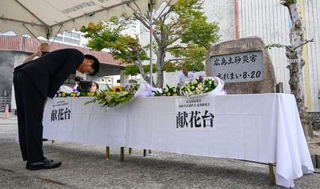 　土砂災害発生から１１年となり、広島市立梅林小の慰霊碑前に設けられた献花台＝２０日午前