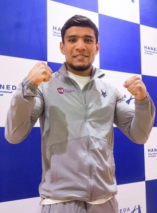 　来日し、ポーズをとるムロジョン・アフマダリエフ＝２４日、羽田空港