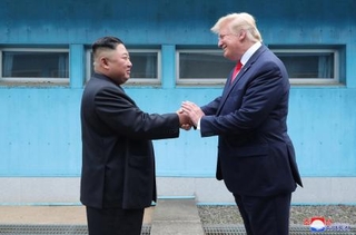 　板門店で対面し、握手する北朝鮮の金正恩朝鮮労働党委員長（左）とトランプ米大統領＝２０１９年６月３０日（朝鮮中央通信＝共同）