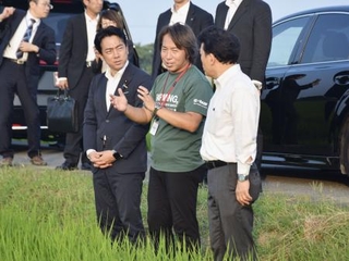 　「乾田直播」の説明を受ける小泉農相（左）＝７月、埼玉県杉戸町