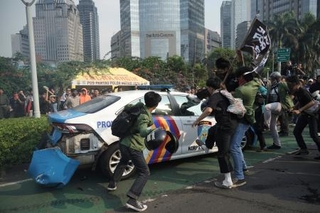 　警察に抗議しパトカーを襲撃する学生ら＝２９日、ジャカルタ（ＡＰ＝共同）