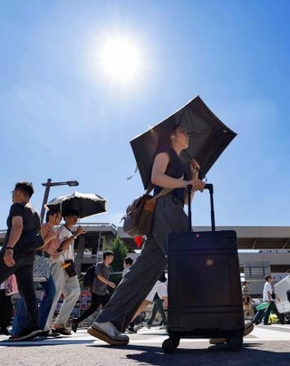 　名古屋市で日傘を差して歩く人たち。最高気温４０度を観測した＝３１日午後
