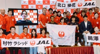 　陸上の世界選手権に向けたＪＡＬの壮行会で、写真に納まる男子１１０メートル障害の村竹ラシッド（中央）ら＝３１日、東京都品川区