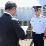 　航空自衛隊新田原基地の担当者に申し入れをする宮崎県の岩切達哉県議（手前）＝１日午後、新富町