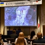 　日・ウクライナ経済復興推進フォーラムで講演するウクライナのゼレンスキー大統領の妻オレナさん（右奥）＝４日午前、東京都内