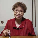　家族らが写った写真を説明する被爆体験の語り部の田中英子さん＝７月、松山市