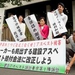 　建設現場のアスベストを巡る訴訟で和解が成立し、横断幕を掲げる原告と弁護団＝７日午後、東京・霞が関