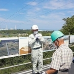 　中間貯蔵施設を巡るバスツアーの参加者に説明する施設の職員（奥）＝９日午後、福島県大熊町