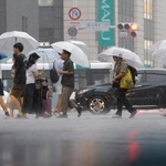 　強い雨が降る中、傘を差して歩く人たち＝１０日午後、福岡市