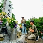 　日航機墜落事故現場の尾根に立つ「昇魂之碑」で手を合わせる遺族＝１２日午前、群馬県上野村