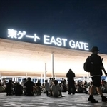 　大阪メトロ中央線が運転見合わせとなり、万博会場で座り込む人たち＝１３日午後１１時２分、大阪市此花区の夢洲
