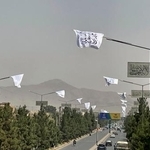 　１４日、アフガニスタンの首都カブールで、復権４年を祝って掲げられたタリバンの旗（共同）