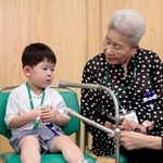 　全国戦没者追悼式を前に取材に応じる最年少参列者の片山純矢ちゃん。右は曽祖母の伊藤早苗さん＝１５日午前１０時２１分、東京・日本武道館
