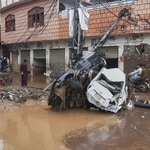 　豪雨による洪水で流され、電柱に衝突した車＝１５日、パキスタン北西部ミンゴラ近郊（ＡＰ＝共同）