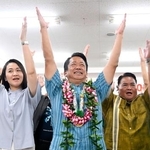 　沖縄県石垣市長選で５選を決め、万歳する中山義隆氏（中央）＝１７日夜、石垣市