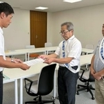 　福井県美浜町役場で、町職員（左）に要望書を提出する原告団長の中島孝さん＝２１日午前