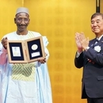 　第５回野口英世アフリカ賞の授賞式で、石破首相（右）から拍手を送られるマリのアブドゥライ・ジムデ博士＝２２日夕、東京都港区の明治記念館（代表撮影）