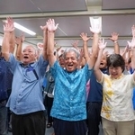 　沖縄県与那国町長選で初当選を決め、万歳する上地常夫氏（中央）＝２４日夜、与那国町