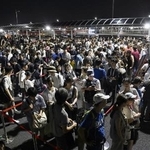　大阪メトロ中央線が運転見合わせとなり、タクシー待ちで西ゲート前に並ぶ大勢の人たち＝１３日、大阪市此花区の夢洲