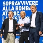 　イタリア・リミニのイベントで登壇した箕牧智之さん（中央）と朝長万左男さん（左）＝２５日（共同）