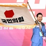　韓国の保守系最大野党「国民の力」の新代表に選出され、党の旗を掲げる張東赫国会議員＝２６日、ソウル（共同）