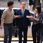 　２７日、ソウル中央地裁に到着した韓悳洙前首相（中央）（聯合＝共同）