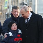　ロシア北西部サンクトペテルブルクを訪問し子供と話すプーチン大統領（右）。後ろに立つのがコザク大統領府副長官＝２月（タス＝共同）