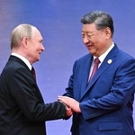 　上海協力機構首脳会議の式典で握手する中国の習近平国家主席（右）と、ロシアのプーチン大統領＝３１日、中国天津市（タス＝共同）