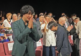 　ベネチア国際映画祭で「ＬＯＳＴ　ＬＡＮＤ／ロストランド」の公式上映後、観客の拍手に応える藤元明緒監督（手前）＝１日、イタリア・ベネチア（共同）