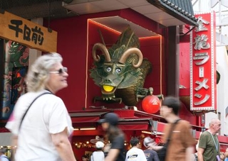 　期間限定でヒツジの角を取り付けた「金龍ラーメン道頓堀店」の竜の巨大立体看板＝３日午前、大阪・ミナミ