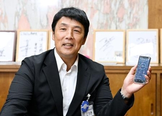 　自身のスマートフォンを手に、インタビューに答える愛知県豊明市の小浮正典市長