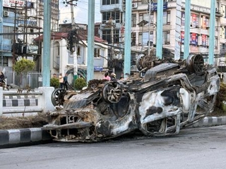 　ネパール・カトマンズの議会前の道路で逆さまとなり、焼け焦げた車＝１１日（共同）
