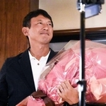 　熊本県八代市長選で初当選を果たし、花束を手に笑顔の小野泰輔氏＝３１日夜、八代市