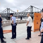　中国遼寧省丹東で、鴨緑江沿いの遊歩道への立ち入りを規制する治安当局者ら。奥は「中朝友誼橋」＝１日（共同）