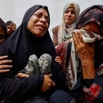 　イスラエル軍の攻撃により犠牲になった息子の靴を抱え、死を悼む母親ら＝８月、ガザ北部ガザ市（ロイター＝共同）