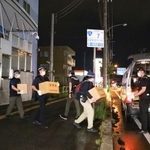 　アレフの施設から押収物を運び出す北海道警の捜査員＝１日午後８時ごろ、札幌市白石区