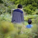 　息子の手を握り、公園を散歩するシングルマザー（本文とは関係ありません）